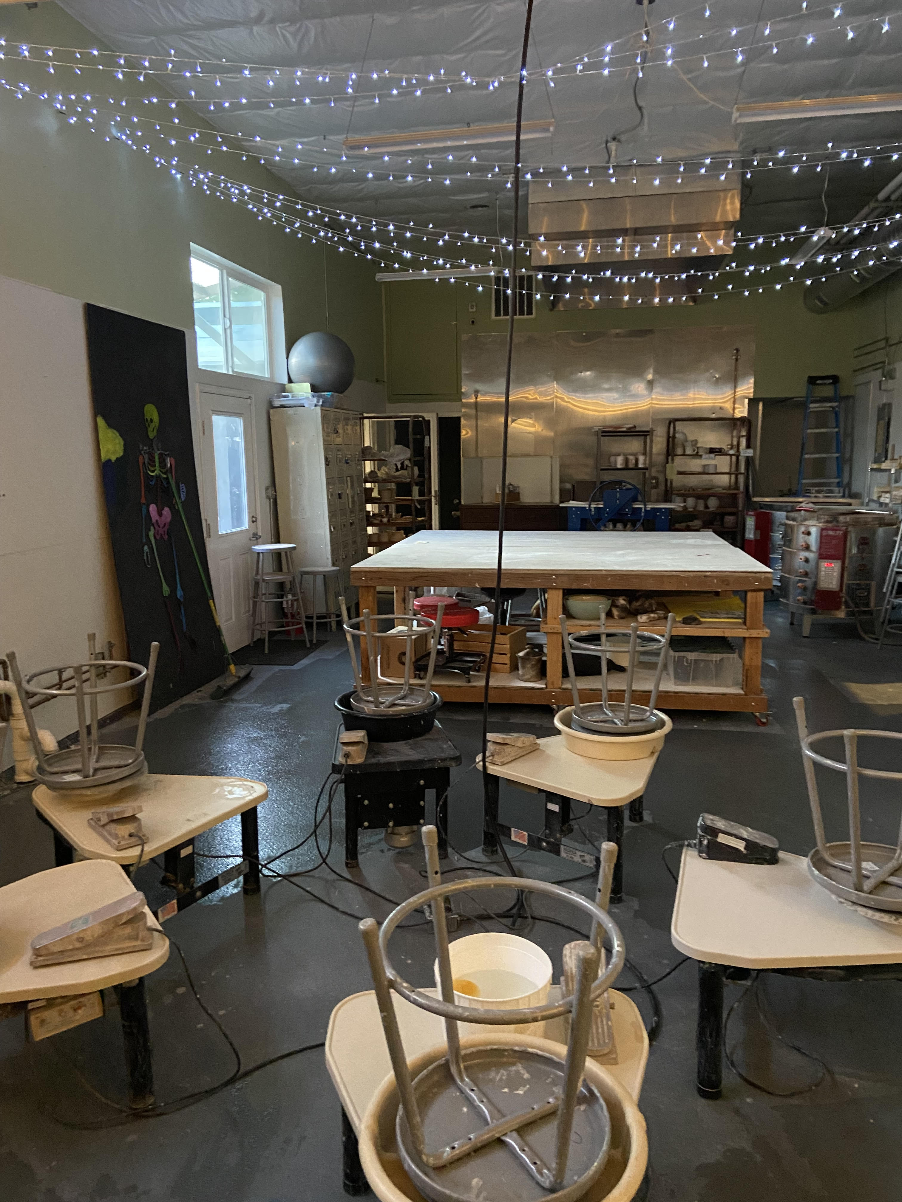 Wildling's ceramic studio showing throwing wheels in the foreground and a large table in the background.